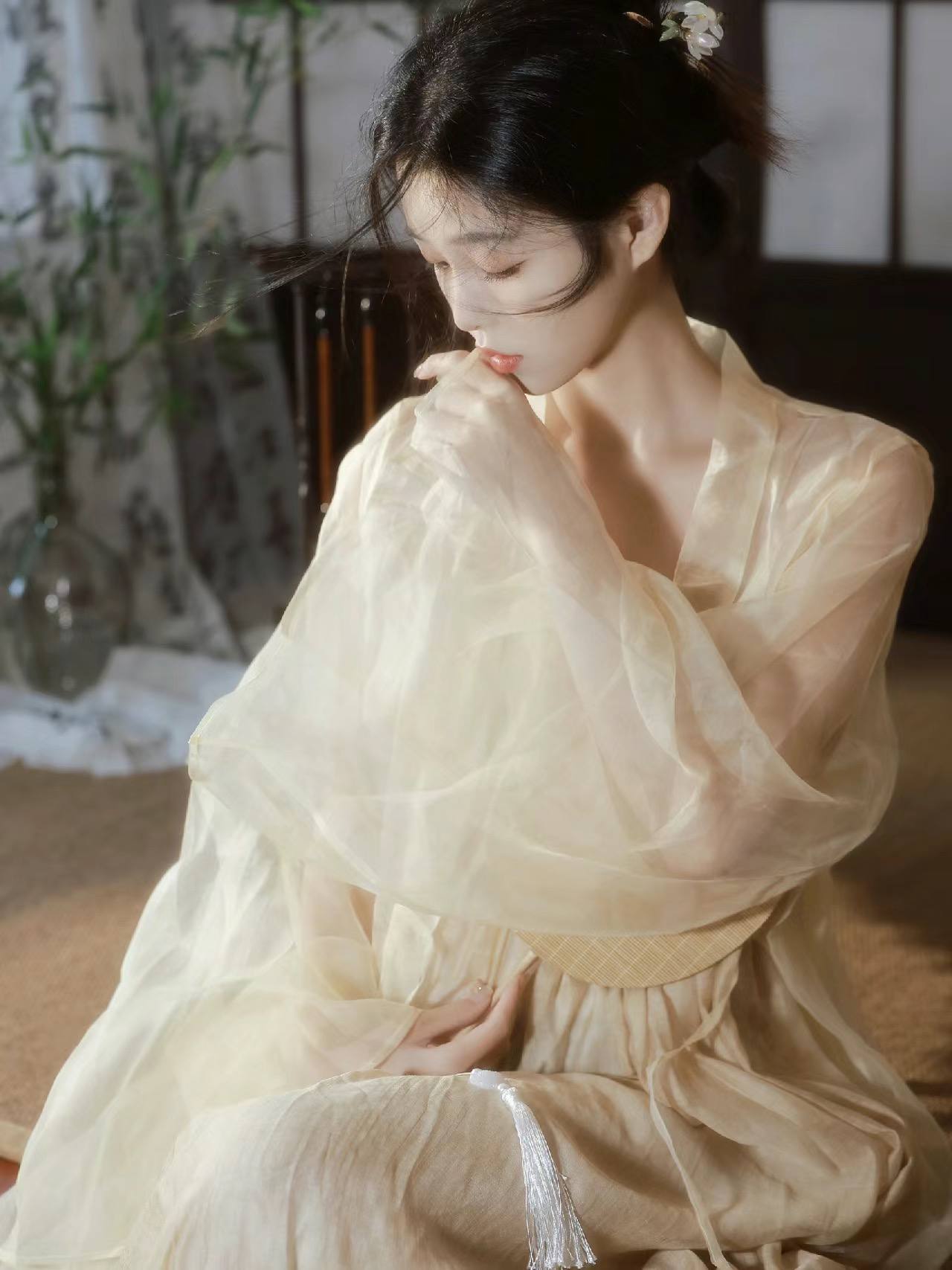 米白衣袍女子倚窗凝思