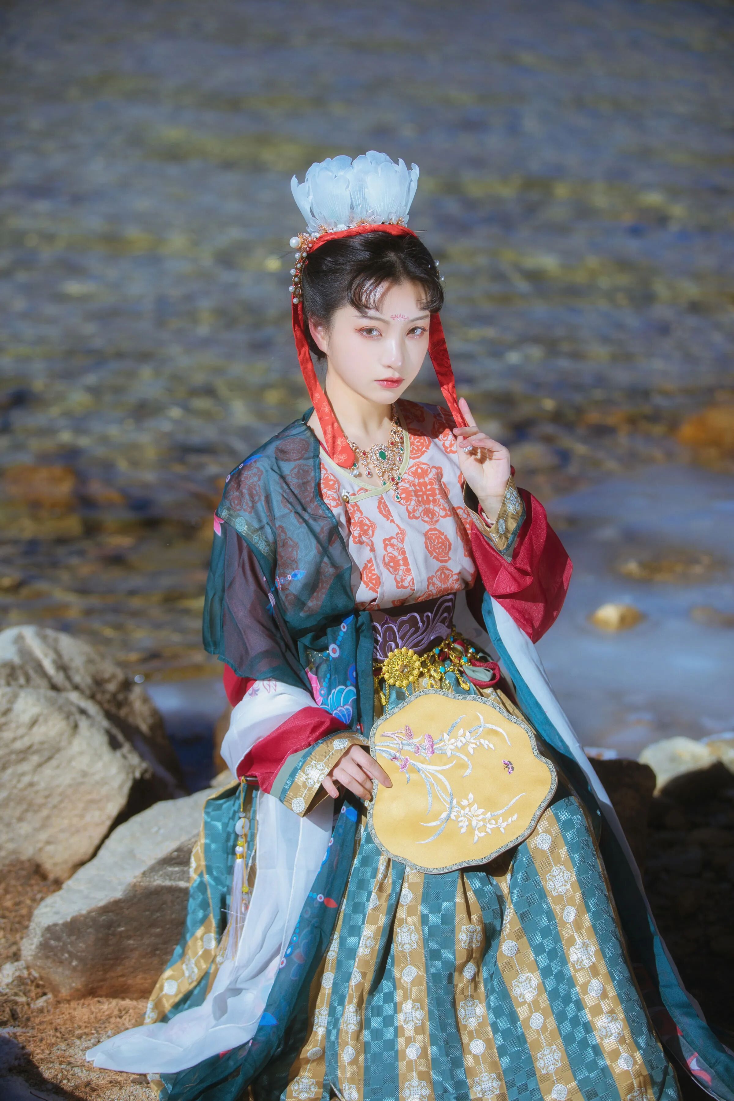 临水踞石,侧颜望向水面
