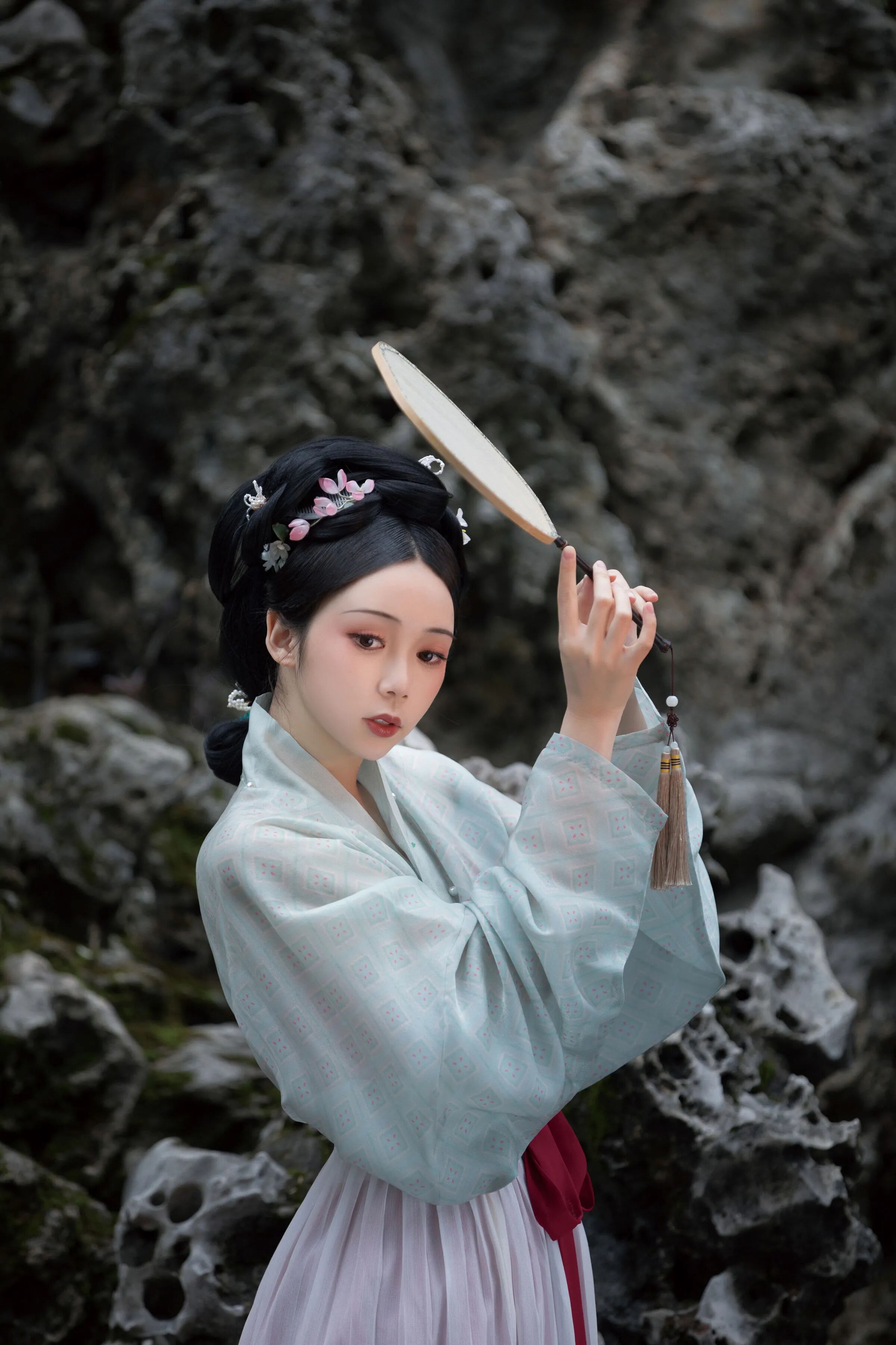 假山前,团扇遮额