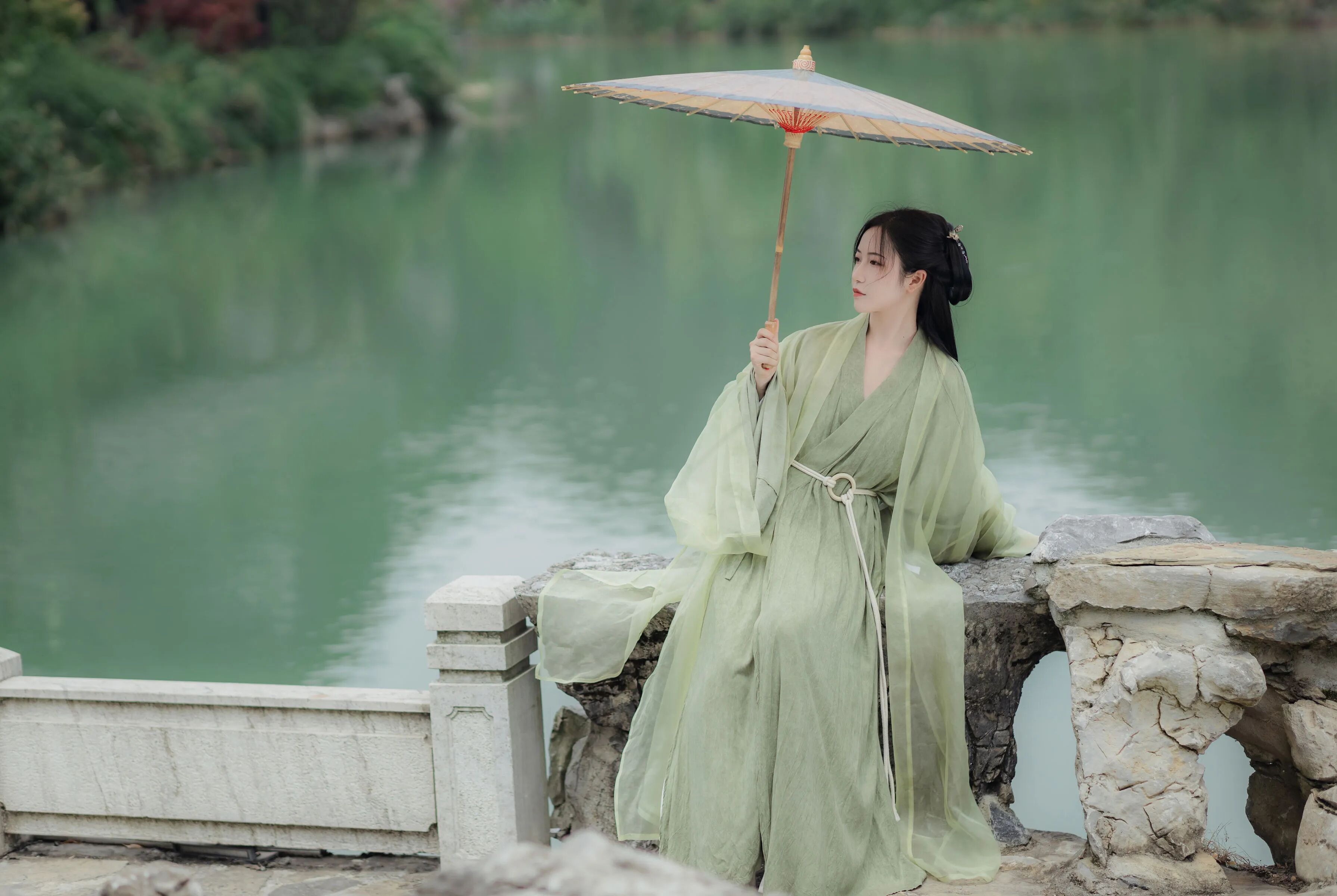 撑伞闲坐湖边石栏