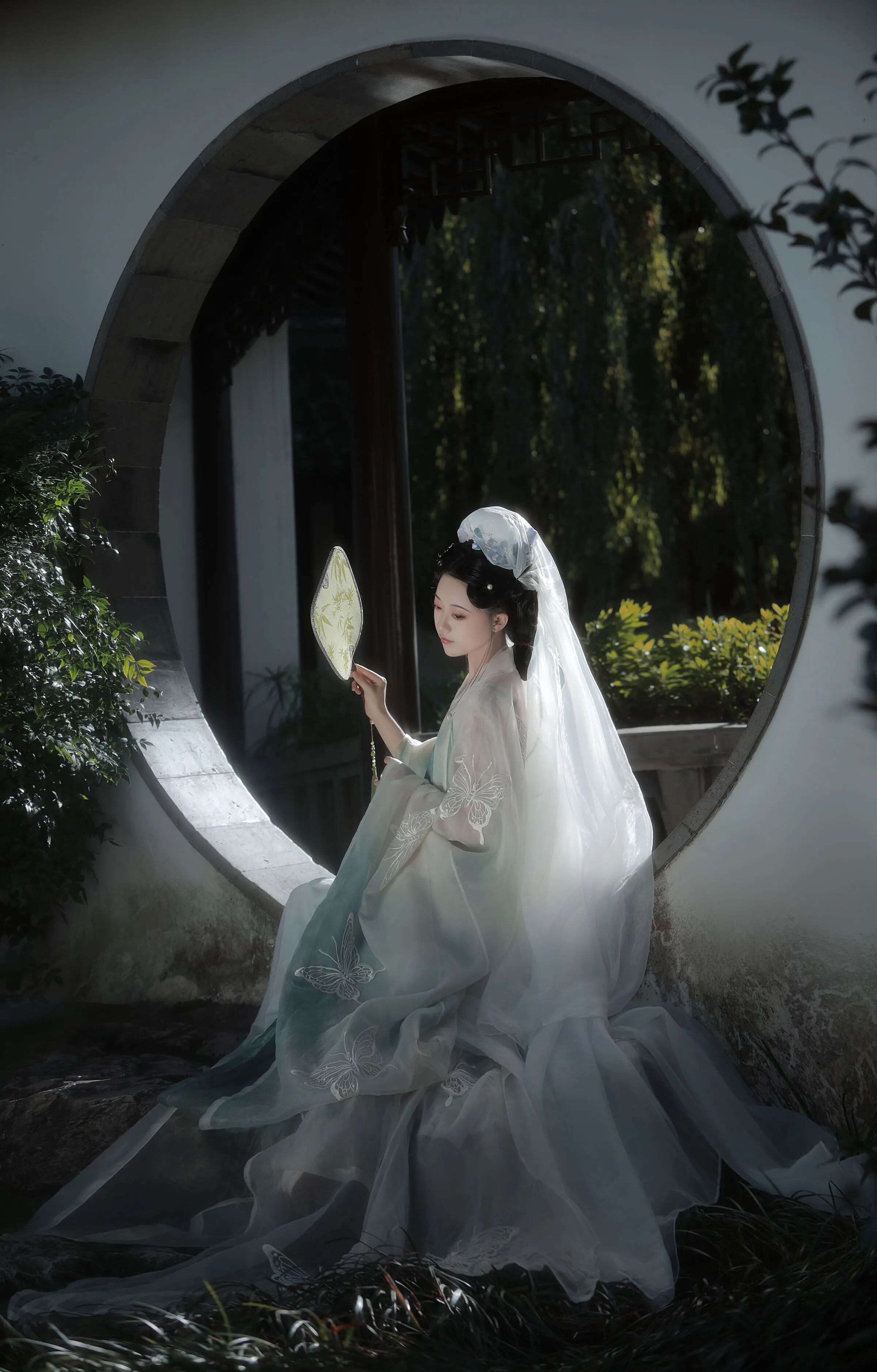 月洞门里,团扇半掩