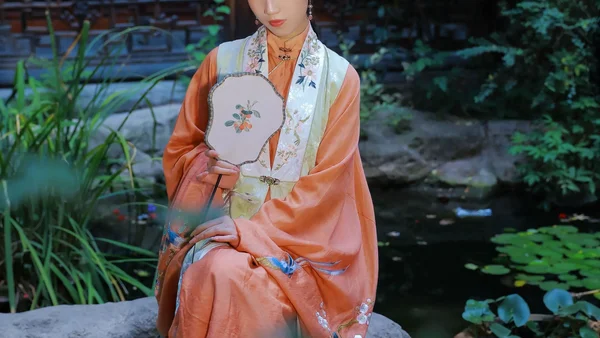 【汉服写真】橘衫提柿坐石畔：园林秋色里，坐姿比立姿更见生活气