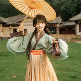 绿衣橘裙坐石阶，笑容甜美如暖阳